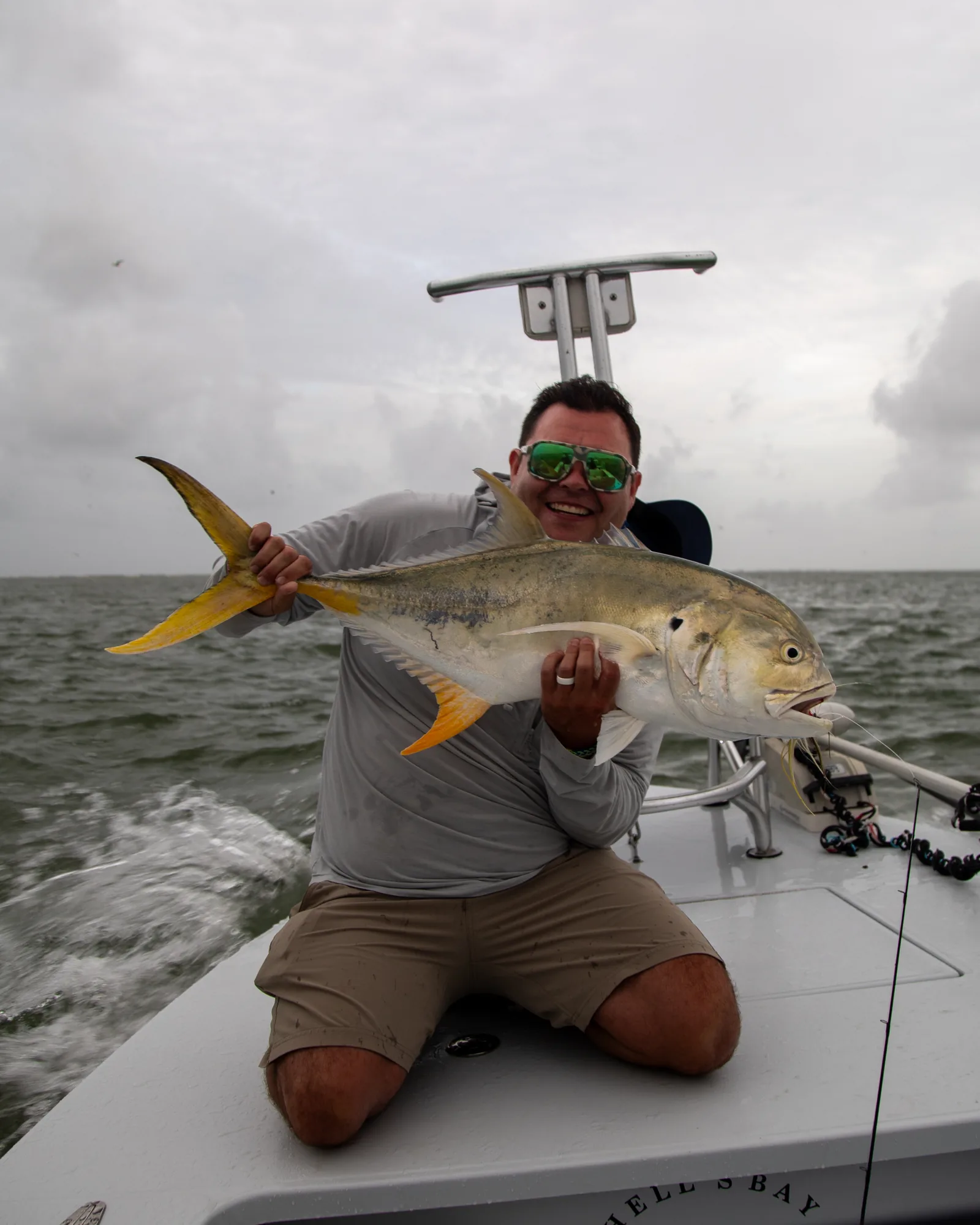 Angler grinning with a jack crevalle taken on fly during a Port O'Connor fly fishing trip on the Texas coast