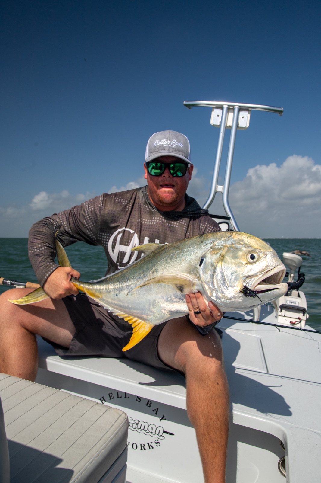 Angler holding a jack crevalle caught on fly aboard a Hell's Bay skiff off Port O'Connor, Texas
