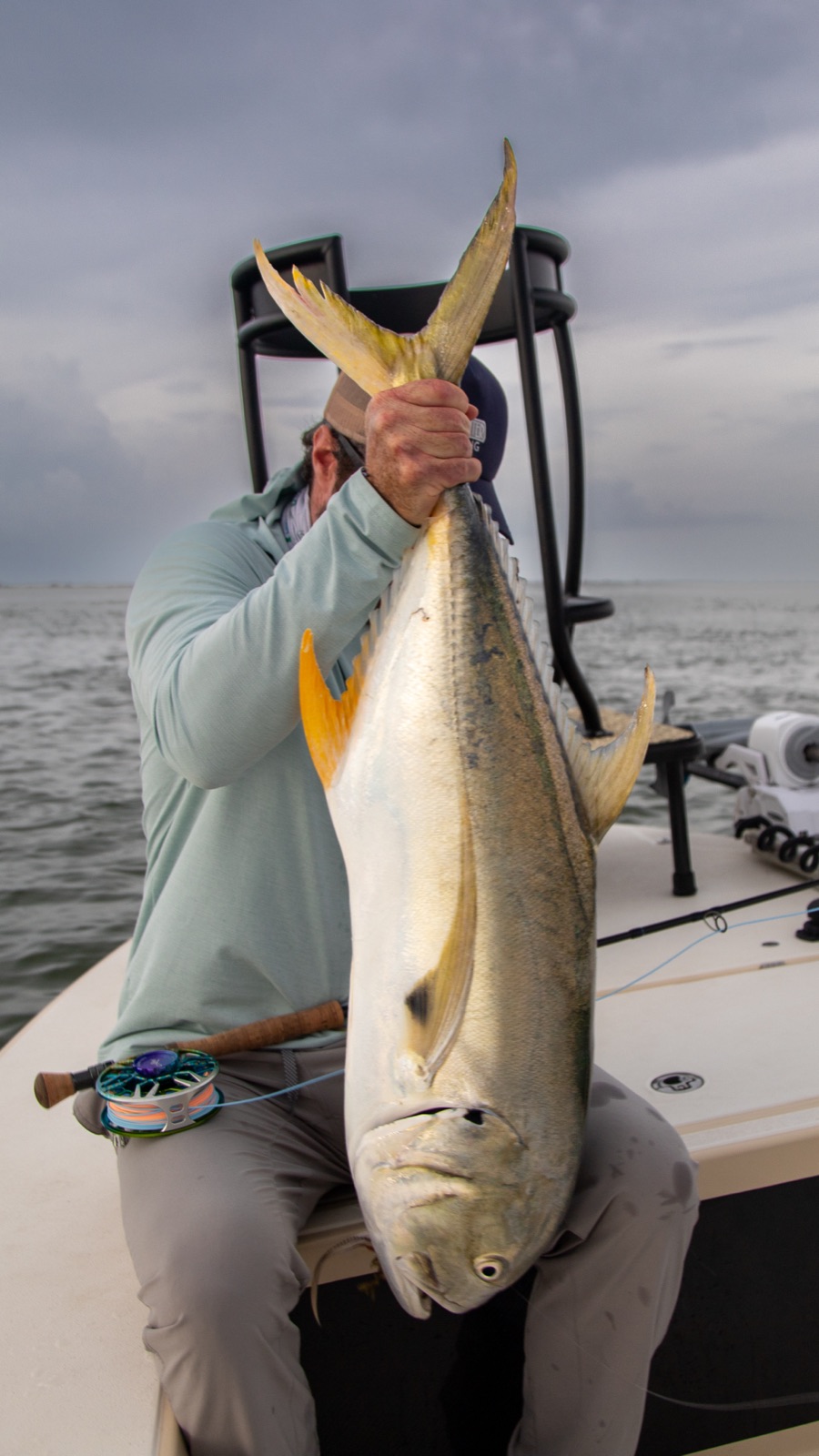 Angler holding up a jack crevalle caught on fly during a Port O'Connor summer trip